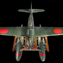 Above view of a green bomber with red roundels on the wings and twin floats in place of wheels.