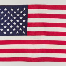 American flag unfolded against white backdrop.