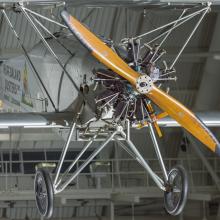 Propellers and fuselage of a biplane. The biplane is hanging in the museum.