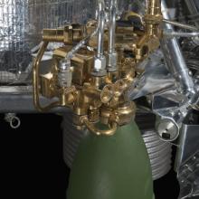 Green painted engine attached to a spacecraft. 