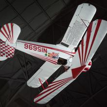 Single-engine white biplane with red accents, registration number N15696