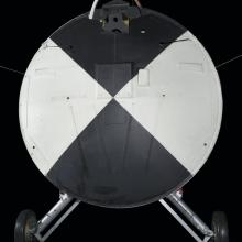 Painted black and white heatshield with wheels attached to the vehicle. 