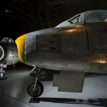 Nose of airplane with a second airplane in the background. 