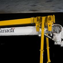 A robotic arm attached to a support beam. 