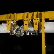 Robotic arm attached to a support beam. 