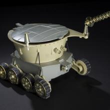 A motorized toy with cone-shaped antenna and six wheels. 