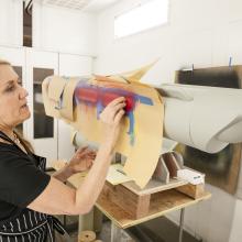 Kim adds red paint to the model's nacelles. 