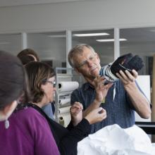 Alan Eustace, a record-holding altitude jumper, holds and inspects the glove of the suit he wore during his record breaking jump.