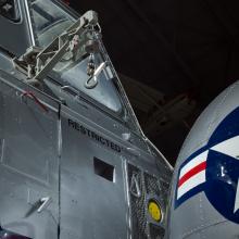 View of a cargo hook and a nose of a helicopter. The nose is open and painted on is the United States Air Force insignia.