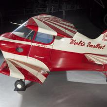 Side view of red and white painted smallest man-carrying plane. 