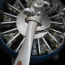 Close up view of a propeller attached to an engine of a plane.