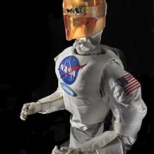 Upper body of a robot with arms, chest with a NASA logo, and an orange face cover.