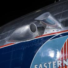 Close up of a silver painted exhaust valve on the fuselage of the plane. 