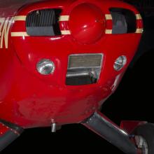 Close up of the nose of a red pained plane. 