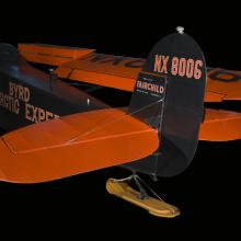 Close up of landing gear and vertical stabilizer of a blue and orange plane. 