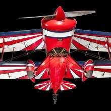 View of the landing gear of a red, white, and blue painted aerobatic biplane. 