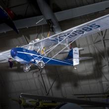 Blue and silver bi-plane hanging in the museum. 