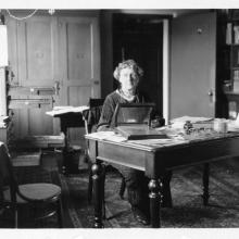 Black and white photo of Cannon at her desk. 