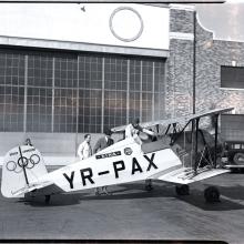 Profile of the Jungmeister with Olympic rings on the tail. Black and white photo. 