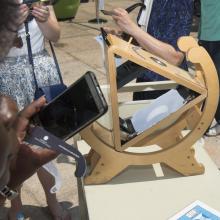 A projection of an eclipsed sun, in a crescent shape, on a triangular shaped device.