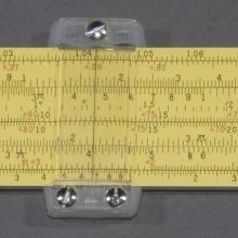 Yellow painted aluminum slide rule, with ruled markings on both sides, Plastic cursor.