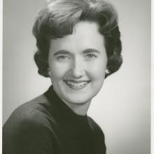 Black and white portrait of a woman smiling.