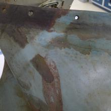 A section of the Horten Ho 229 V3 is tested to determine if a certain cleaning method will move a preservative coating. In this instance, a small strip of the section of the gray monoplane is significantly cleaner than before.