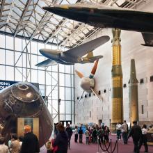 A large wind tunnel fan previously used by NASA hangs on a wall of the Museum's Washington, D.C. building alongside other museum objects.