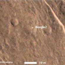 A partial satellite view of Mars with the location of a lander spacecraft indicated as a white dot near the center.