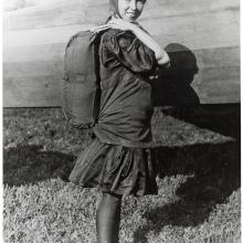 Tiny Broadwick, a white female parachutist, wears a back-pack parachute.