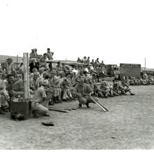 A large group of people view a baseball game played in India.