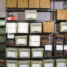 A multi-shelf storage display with twenty-one visible boxes and multiple other folders.