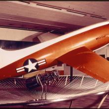 Side view of orange and white military monoplane. Registration number "6062" painted on the fin in black paint.