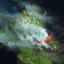 Satellite view of an erupting volcano in the Galapagos Islands. The view has been edited to show different colors which represent different aspects of the photo.