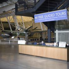 Diagonal front view of a guided tours desk inside the Steven F. Udvar-Hazy Center. The desk is located near a popular reconnaissance aircraft in the Museum's collection.