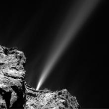 Black and white perpsective of a jet of gases exploding from the surface of a comet.