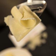 Close-up view of a slice of light yellow-colored cheese.