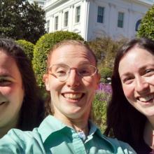 Three Museum educating staff members pose informally outside the White House.