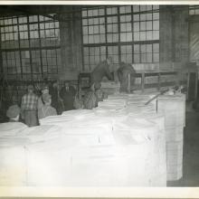 A group of men employed with the Northwestern Aeronautical Corporation unload cases of turkeys prior to a holiday giveaway to employees.