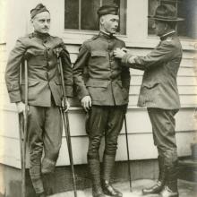 A male second lieutenant receives a service medal. The lieutenant is injured and using a cane.