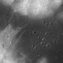 Satellite view of a region of the Moon that is mostly flat but features some small craters.