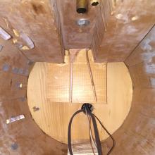 Top view of the interior of the vertical hull section of a spaceship studio model from the show Star Trek. The hull is made from light brown colored wood and plexiglass.