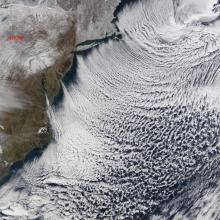 Satellite view of a group of cloud formations that look like organized rows of clouds.