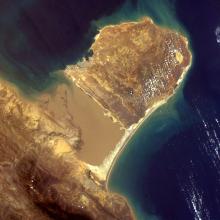 Satellite view of a peninsula with brown ground on the coast of Venezuela. 