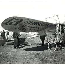 Side view of wooden and metal monoplane. Under the left wing, the plane is marked as owned by the "U.S. Mail".