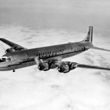 Side view of commercial aircraft in flight. Aircraft features four engines and American Airlines livery.