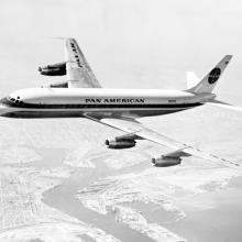 Side view of commercial aircraft with four engines and Pan American Airways livery. Aircraft is in flight.