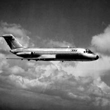 Side view of commercial jet aircraft in flight. The jet features Trans-Texas Airlines livery and has two engines placed near the rear of the fuselage.