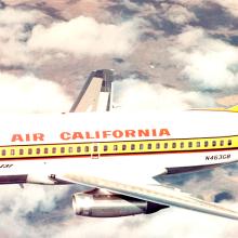 Side view of commercial aircraft in flight. Aircraft features two engines and white, yellow, black, and red Air California livery.