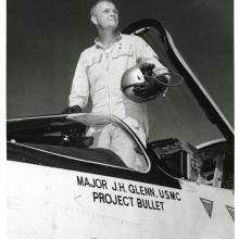 John Glenn standing in the cockpit his F8U-1P Crusader